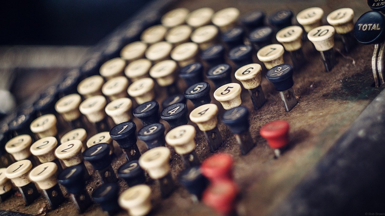 An old cash register with push keys, frontal, close-up, bit dirty
