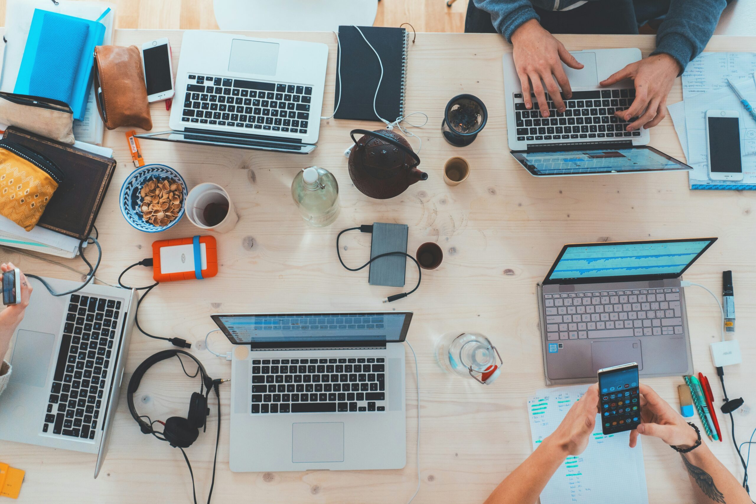 Original photo of gadgets on a table from unsplash https://unsplash.com/photos/people-sitting-down-near-table-with-assorted-laptop-computers-SYTO3xs06fU