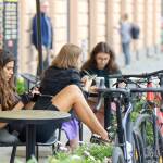 People at tables outside a cafe, with parked bicycles, thanks to surprising_media at Pixabay